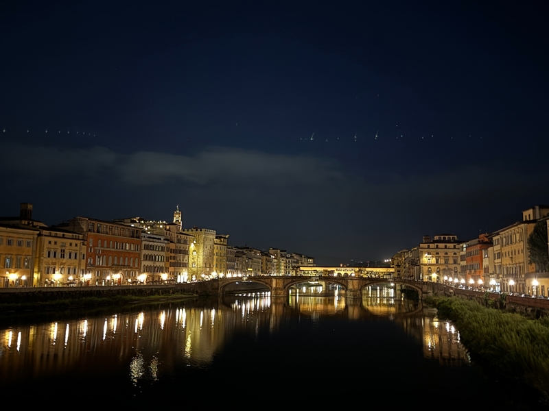 The Arno River at night with the Ponte Vecchio in the distance The Arno River at night with the Ponte Vecchio in the distance
