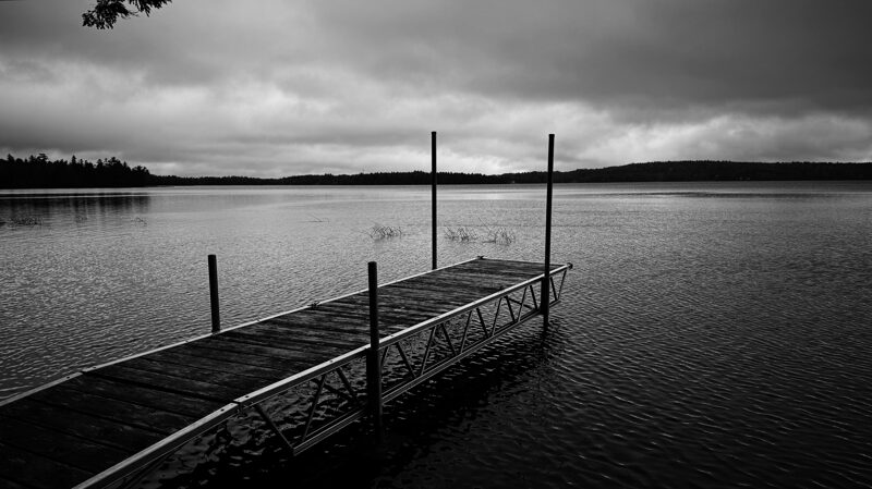 Post-Phillipe Dark clouds hang heavy over a lake after a storm of wind and rain. A boat dock stretches out into the water.