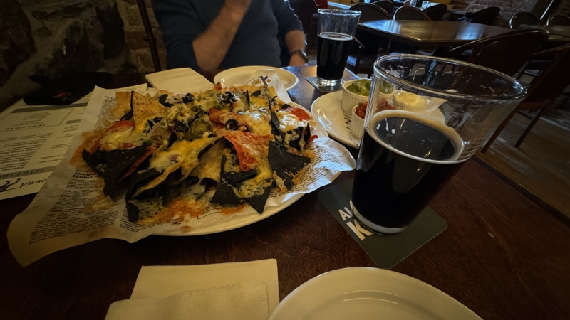 Checked in: The Brown Hound Public House A plate of baked nachos covered in cheese, olives, and jalapeños with a pint of stout next to it