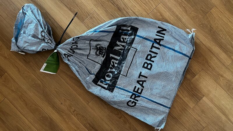 A light blue bag with the Royal Mail logo on it and a large uppercase Great Britain printed on it