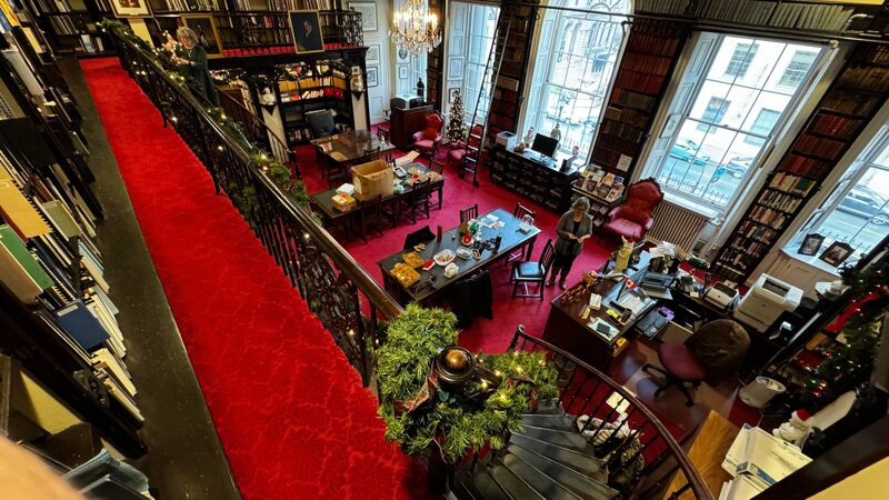 Library decorations Looking down into a library's reading room from the second-floor gallery, Christmas decorations are being added with dark red carpet adding to the holiday feeling.