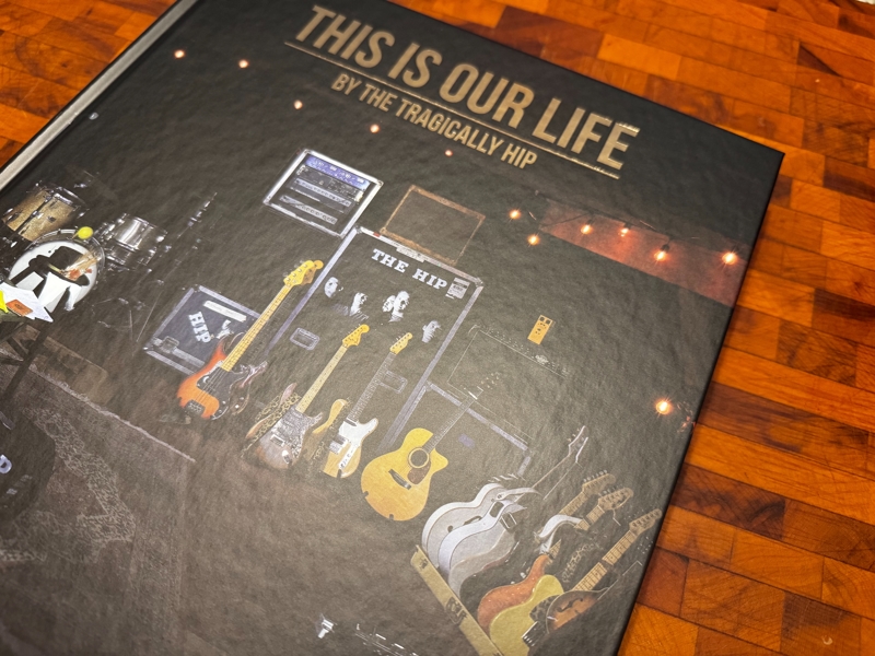 This Is Our Life A dark-covered book title This Is Our Life sits on a wooden table