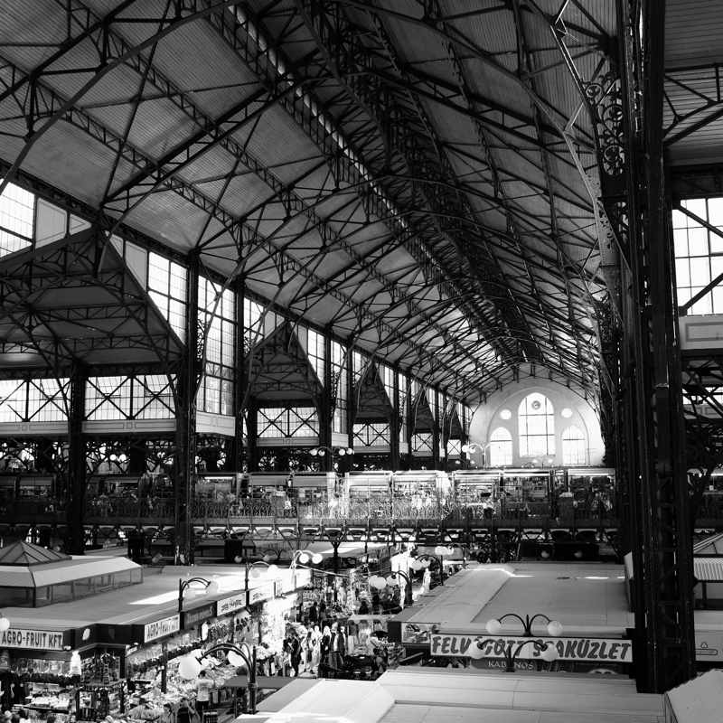 A grand market hall is seen from inside with large vaulted ceilings and huge windows filtering light down below