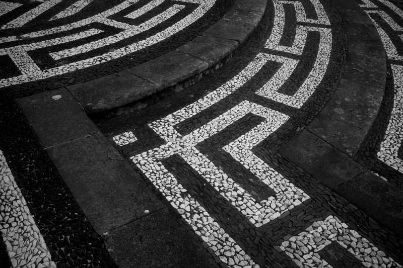 Black-and-white stones are arranged in a geometric pattern to make steps in front of a church